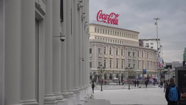 Пешеходы Прогуливаются Центре Скопье Македония Фоне Здания Coca Cola — стоковое видео