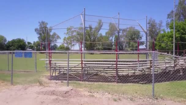 在棒球场上方的一个上升的镜头显示背景是美国的墨西哥边境墙 — 图库视频影像