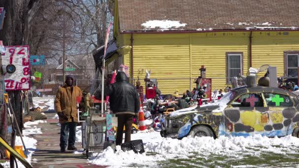 黒人男性は放棄されたアイテムや芸術品でいっぱいのデトロイトの近所を歩く — ストック動画