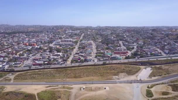 メキシコとサンディエゴをティフアナから隔てる国境の壁のフェンスの上の高い空中 — ストック動画