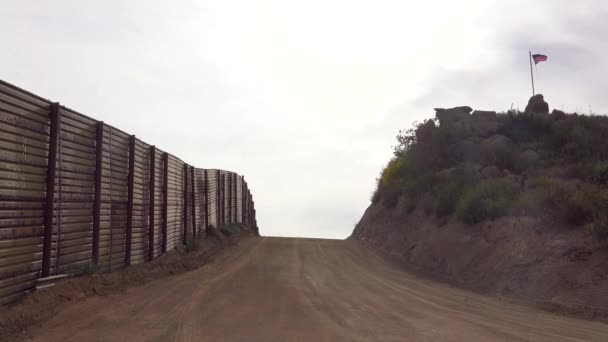 Uzaklarda Amerikan Bayrağı Dalgalanan Meksika Sınırı Boyunca Boş Bir Yol — Stok video