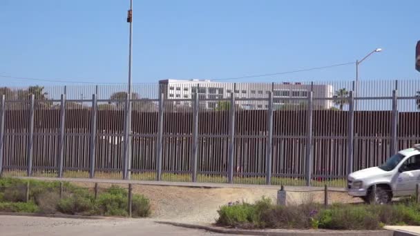 圣地亚哥和蒂华纳之间的边境墙前面有一辆边境巡逻车经过 — 图库视频影像