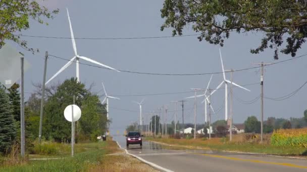 代替エネルギーを生産する巨大な風力発電所の近くの高速道路を走行する車 — ストック動画