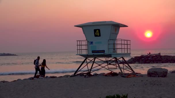 Ένα Ηλιοβασίλεμα Πίσω Από Ένα Ναυαγοσώστη Μια Παραλία Της Καλιφόρνια — Αρχείο Βίντεο