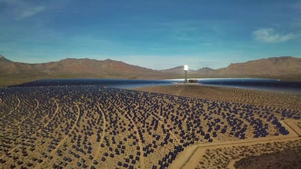 巨大な太陽光発電アレイを見下ろす丘の上に立っている写真家のドローン航空機 プリム ネバダ州 — ストック動画