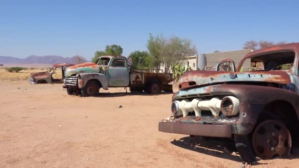 在纳米比亚Solitaire小绿洲定居点附近的道路上排起了被遗弃和生锈的卡车和汽车 — 图库视频影像