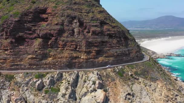 在南非开普敦附近的查普曼山路上 一辆汽车沿着大海在一条危险的狭窄山路上行驶时的航拍 — 图库视频影像