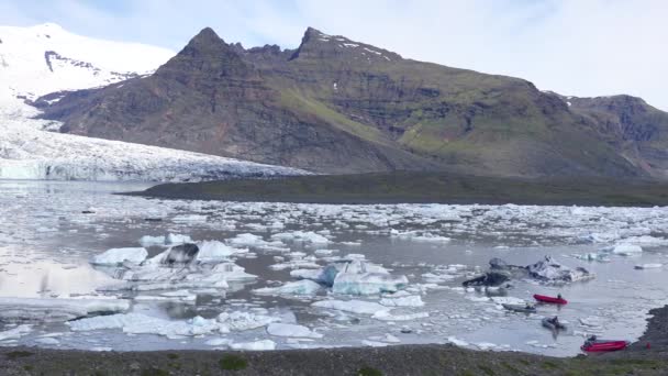 アイスランドのFjallsarlonの氷山で満たされた巨大な氷河ラグーンを横断するゾディアックボートの気候研究者は 地球温暖化と気候変動を示唆しています — ストック動画