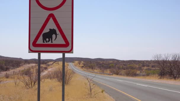 在非洲纳米比亚的一条土路上 一辆吉普车经过时小心大象横越的标志警告游客 — 图库视频影像