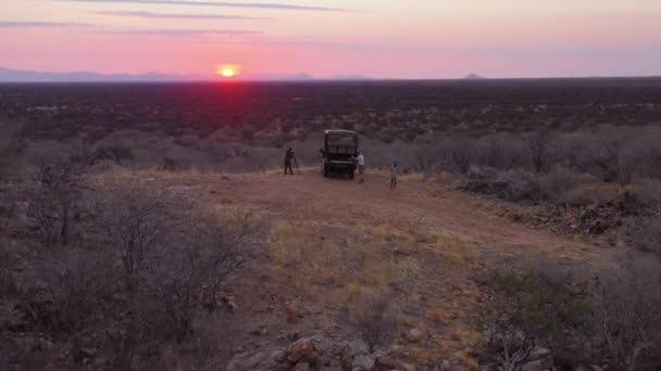 ナミビアの広大な美しいErindiゲームプレザーでサファリジープで夕日を楽しむ観光客の航空 — ストック動画
