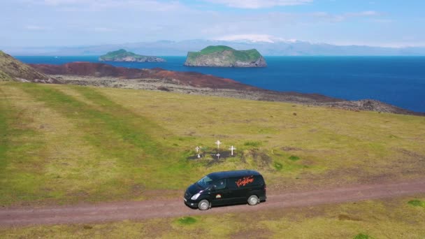 西マン諸島のアイスランドの未舗装の道路を走行する黒いキャンパーバンの上に空中 — ストック動画