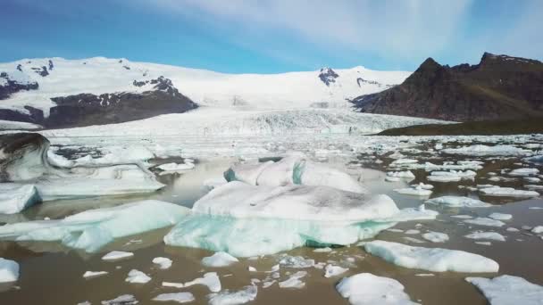 アイスランドのFjallsarlonの氷河で満たされた巨大な氷河ラグーンの間の遅い空中は 地球温暖化と気候変動を示唆しています — ストック動画