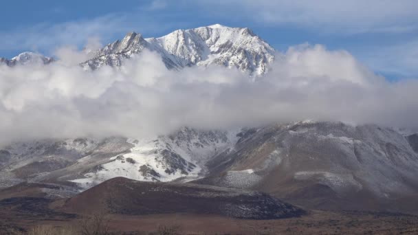 時間は山の近くの東シエラネバダ山脈の山々の後ろの冬に美しい雲を崩壊させます カリフォルニア州ホイットニー — ストック動画