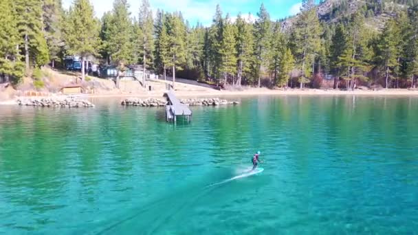 男子骑水翼飞碟电子冲浪板横渡加州塔荷湖举行了一个极端的水翼飞碟运动示范 — 图库视频影像