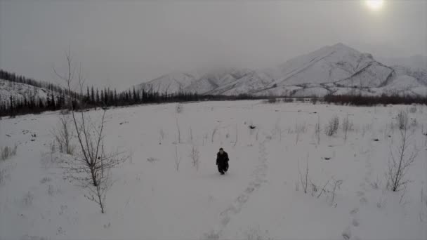 北極の雪景色の中を男が走り抜ける — ストック動画