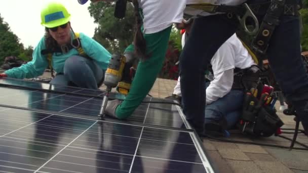 Arbeiter Installieren Sonnenkollektoren Auf Dem Dach Eines Mittelklassehauses — Stockvideo