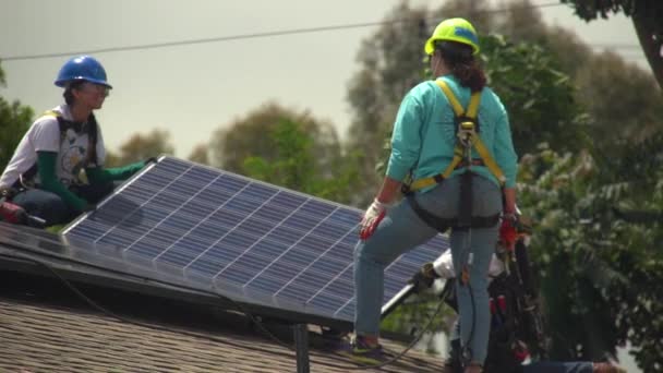 Arbeiter Installieren Sonnenkollektoren Auf Dem Dach Eines Mittelklassehauses — Stockvideo