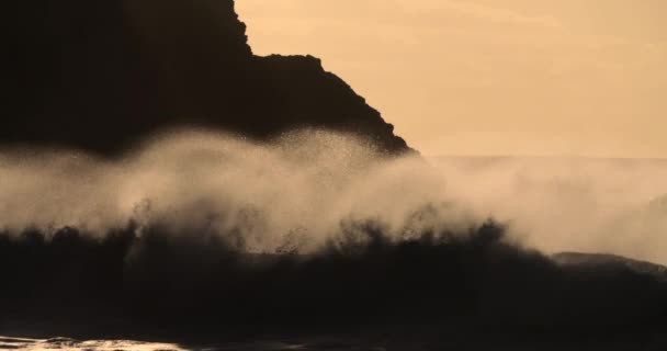 スローモーションで黄金の光の岩の海岸に対して大規模な波が壊れ — ストック動画