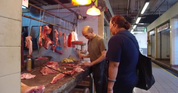 香港的一个肉商用刀切肉给顾客吃 — 图库视频影像