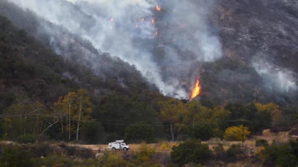 トーマスの火は丘の中で燃え 前景を通り過ぎる南カリフォルニアのエジソントラックでカリフォルニア州おじゃいの上のブラシで燃えます — ストック動画
