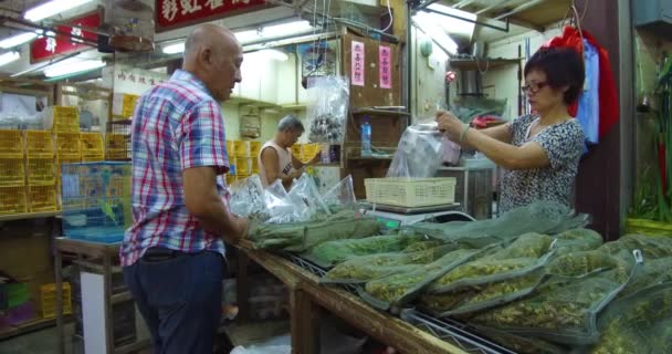 買い物客は 中国の香港のペットショップで鳥を養うために大きなバスケットで販売されています — ストック動画