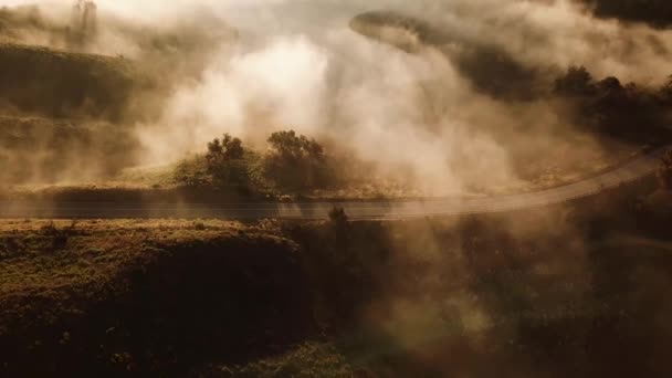 새벽이나 일몰에 안개가 시골을 여행하는 자동차의 공중비행 — 비디오