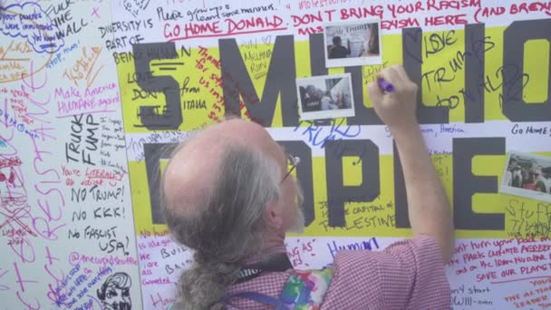 2018 抗議者はドナルド トランプ大統領の訪問に抗議するためにロンドンの路上でドナルド トランプにメッセージを添えて大きな壁に署名する — ストック動画