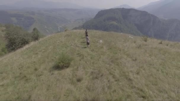 ボスニア 旧ユーゴスラビアのルコミール村の近くの丘の上を歩く人々の空中 — ストック動画