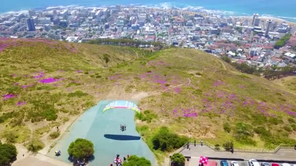 背景にケープタウン 南アフリカのダウンタウンの街とパラグライダーの上に空中ドローン — ストック動画