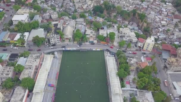 ハイチのポートオープリンスのシテ ソレイユ地区にあるスラム ファヴェーラ シャンティの町の上空にはサッカースタジアムが前景にあります — ストック動画