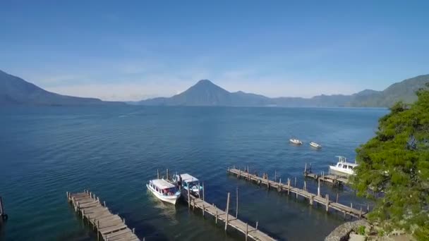 グアテマラのアマティトラン湖にあるボートドックの上の空中は 遠くのパカヤ火山を明らかにしています — ストック動画