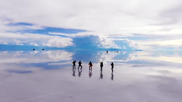Aérea Gente Silueta Bailando Lago Salinas Uyuni Con Reflejos Perfectos — Vídeos de Stock