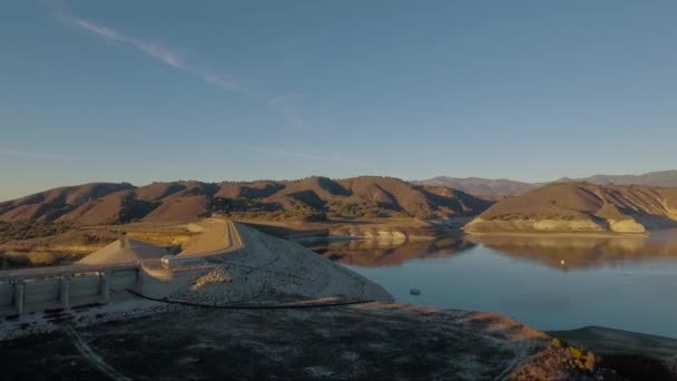 干ばつの間 カリフォルニアの乾燥した湖とダムの上に空中上昇 — ストック動画