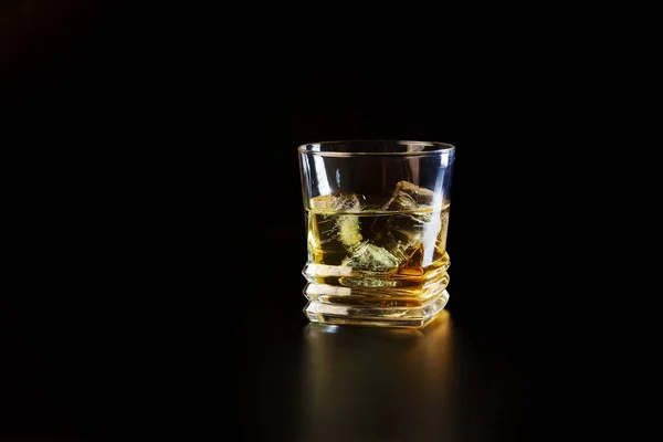 Vaso de alcohol sobre mesa negra — Foto de Stock