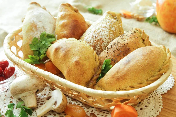 Russian pirozhki, baked patties or pies on basket — Stock Photo, Image