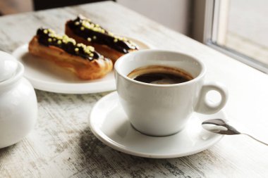 Taze siyah kahve fincan kahve eklerleri ile beyaz plaka