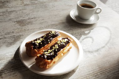 Taze siyah kahve fincan kahve eklerleri ile beyaz plaka