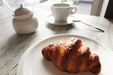 Kruvasan ile taze siyah kahve ile beyaz plaka