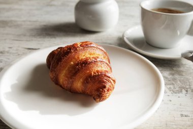 Kruvasan ile taze siyah kahve ile beyaz plaka