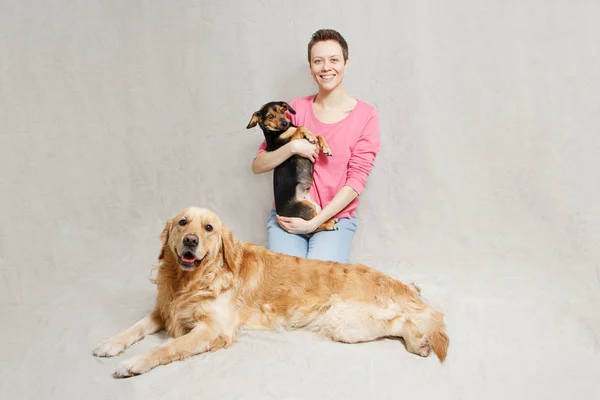Junge Frau im rosa Pullover mit zwei Hunden — Stockfoto