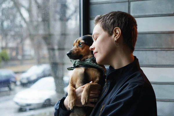 woman and dog by the window on quarantine