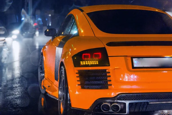 Aggressive und brutale orangefarbene Sportwagen auf verregneter Straße Bild nützlich für Hintergrund — Stockfoto