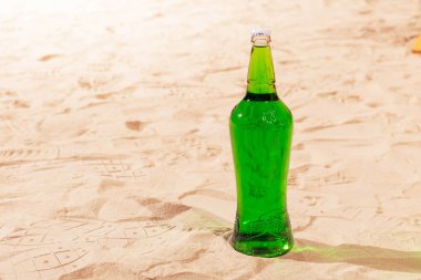 Turuncu ahşap kutu ve limonata şişe yaz aylarında güneşli sahilde okyanus palmiye yaprakları ile