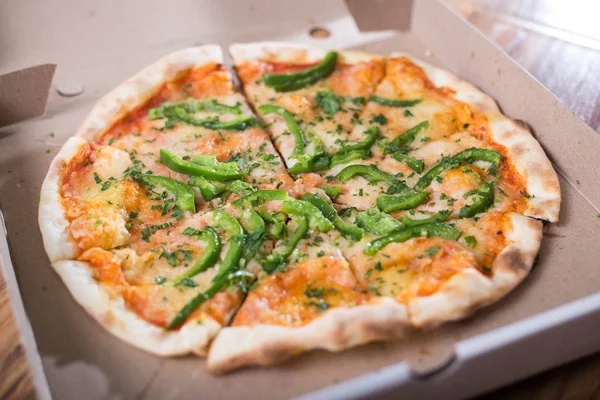 Italian pizza with green pepper in paper box tasty macro picture