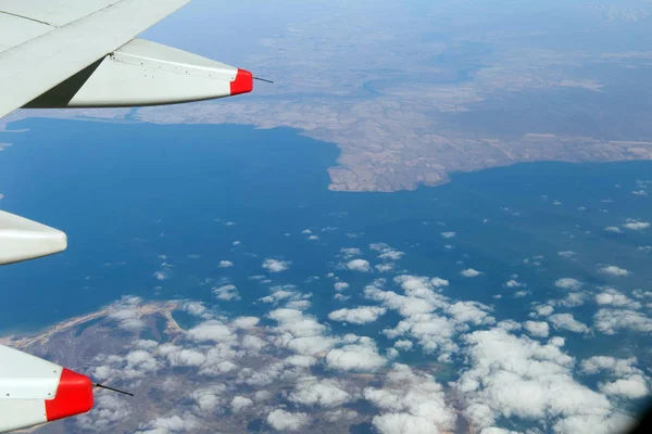 Molnen berg och himlen sedd genom fönstret på ett flygplan — Stockfoto