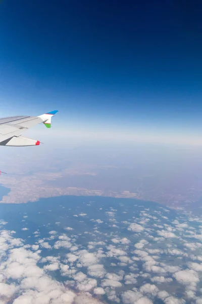 Molnen berg och himlen sedd genom fönstret på ett flygplan — Stockfoto