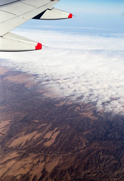 Molnen berg och himlen sedd genom fönstret på ett flygplan — Stockfoto