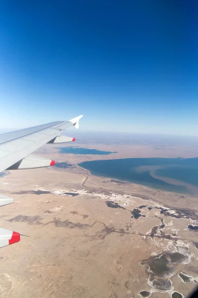 Awan pegunungan dan langit seperti yang terlihat melalui jendela pesawat terbang — Stok Foto