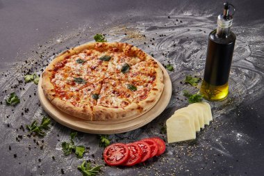 Bütün İtalyan lezzetli taze pizza domates ve biber karanlık bir arka plan üzerinde. Pizza siyah masada. maddeler ile