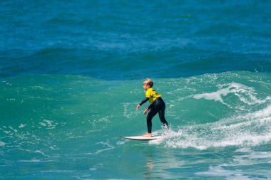 Surfer in Ribeira de Ilhas Beach in Ericeira Portugal. clipart